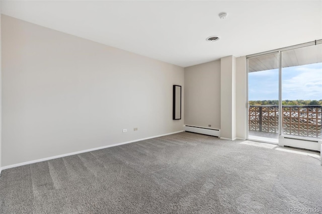 unfurnished room featuring baseboard heating, carpet, and expansive windows