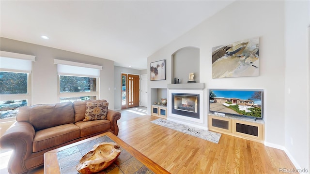 living room with baseboards, a multi sided fireplace, vaulted ceiling, recessed lighting, and wood finished floors