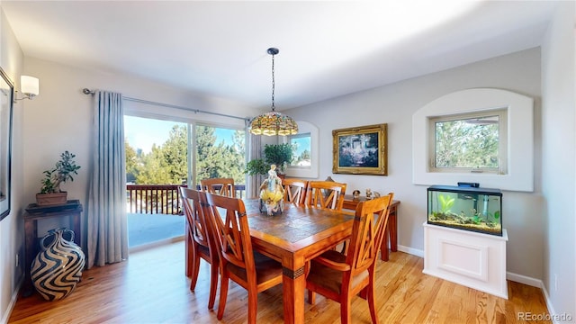 dining space with baseboards, light wood-type flooring, and a wealth of natural light