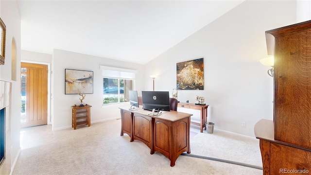 office area featuring vaulted ceiling, light colored carpet, and baseboards