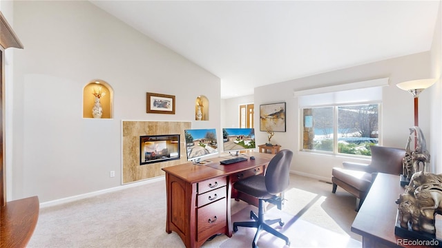 office area featuring high vaulted ceiling, baseboards, light colored carpet, and a tiled fireplace