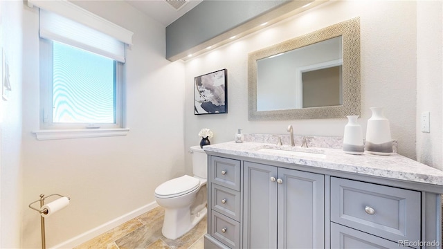 bathroom featuring visible vents, baseboards, toilet, and vanity