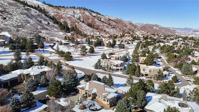 snowy aerial view featuring a mountain view and a residential view