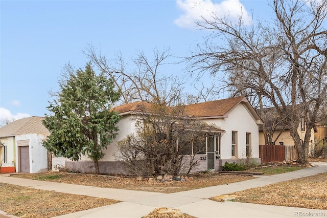 view of front of property with stucco siding and fence