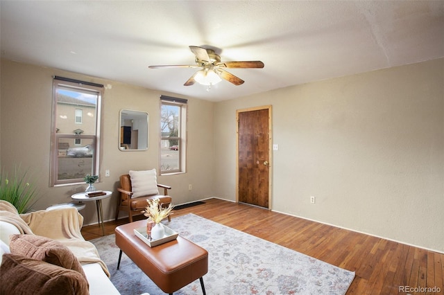 living area with visible vents, ceiling fan, and wood finished floors