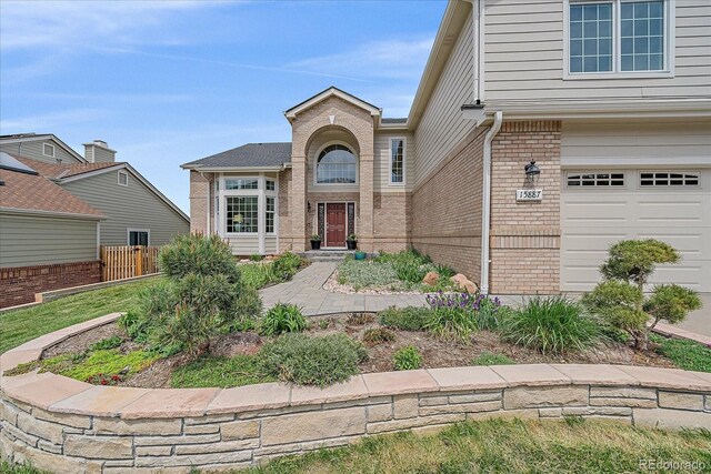 view of exterior entry with brick siding and fence
