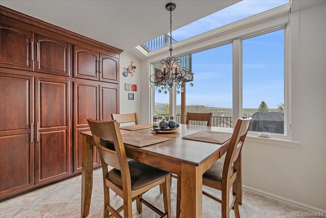 dining area featuring baseboards and a chandelier
