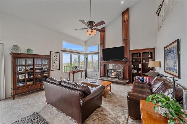 living room featuring high vaulted ceiling, a glass covered fireplace, and ceiling fan