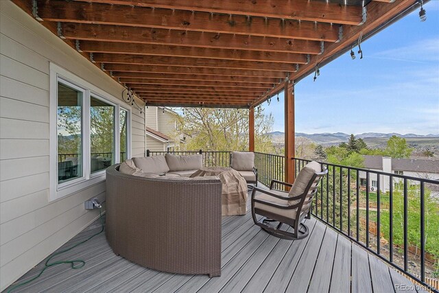 wooden terrace featuring a mountain view and outdoor lounge area
