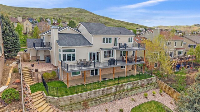 back of house featuring a fenced backyard, a chimney, and a residential view
