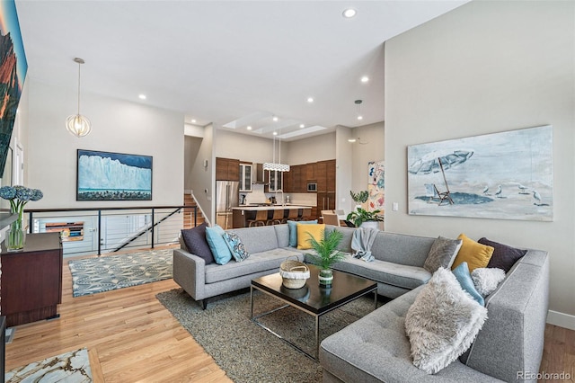 living room featuring light hardwood / wood-style flooring and a towering ceiling