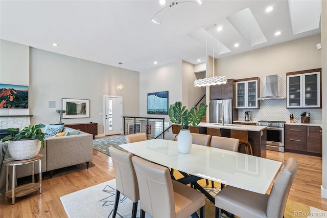 dining area with a towering ceiling and light hardwood / wood-style floors