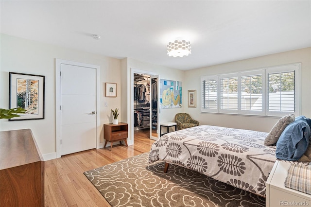 bedroom with wood-type flooring, a closet, and a spacious closet