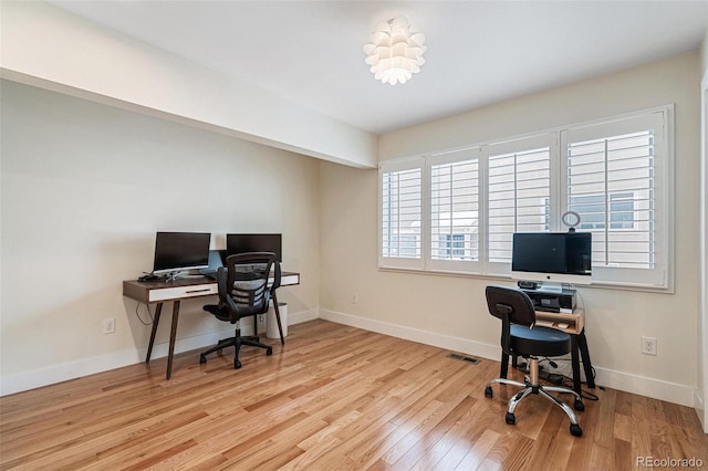 home office with light hardwood / wood-style flooring