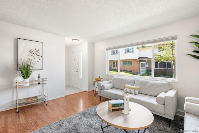 12648 W Virginia Ave, Lakewood, CO 80228 - living area featuring a textured ceiling, baseboards, and wood finished floors