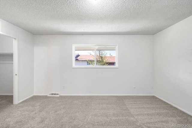 12648 W Virginia Ave, Lakewood, CO 80228 - unfurnished bedroom with a walk in closet, carpet floors, a textured ceiling, and visible vents