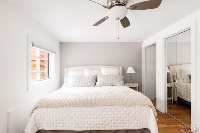 bedroom with a closet, wood finished floors, and ceiling fan