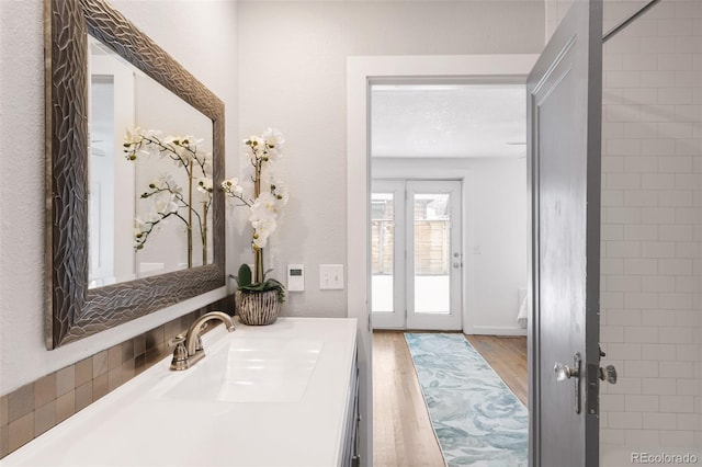 bathroom with french doors, wood finished floors, and vanity