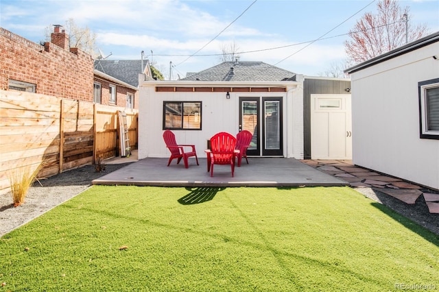 back of property with a lawn, roof with shingles, and a fenced backyard