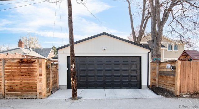 detached garage featuring a gate and fence