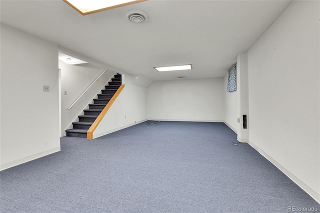 finished below grade area with visible vents, baseboards, carpet floors, and stairs