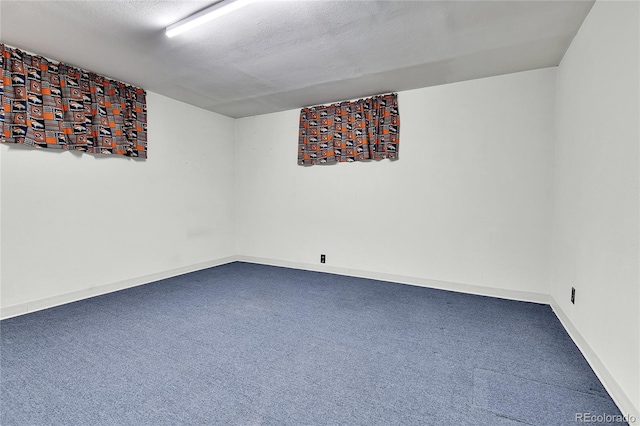 spare room featuring carpet and baseboards