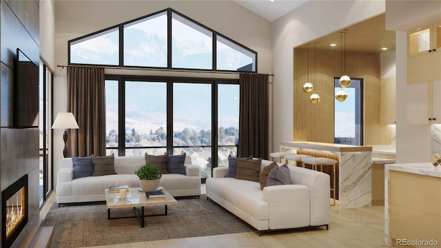 living room featuring a high end fireplace, a towering ceiling, and plenty of natural light