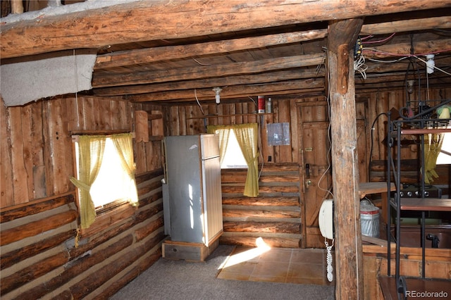 basement with carpet, a healthy amount of sunlight, and refrigerator