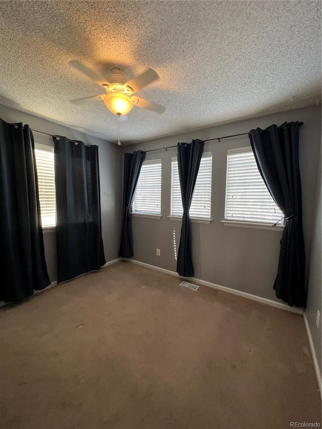 spare room featuring carpet flooring, a textured ceiling, and ceiling fan