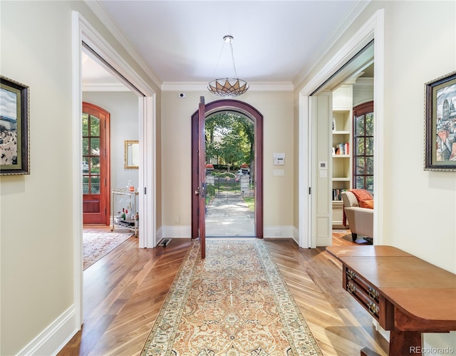 foyer entrance with light hardwood / wood-style flooring and ornamental molding