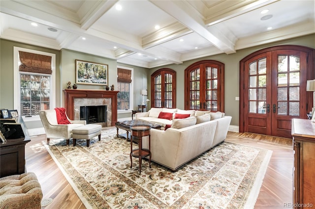 living room featuring crown molding, coffered ceiling, a premium fireplace, beam ceiling, and french doors