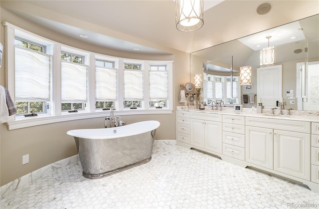 bathroom with tile patterned floors, vanity, a wealth of natural light, and a tub