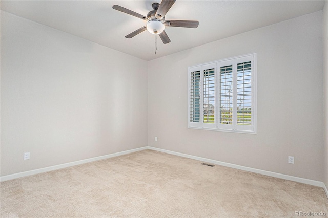 carpeted empty room featuring baseboards, visible vents, and ceiling fan