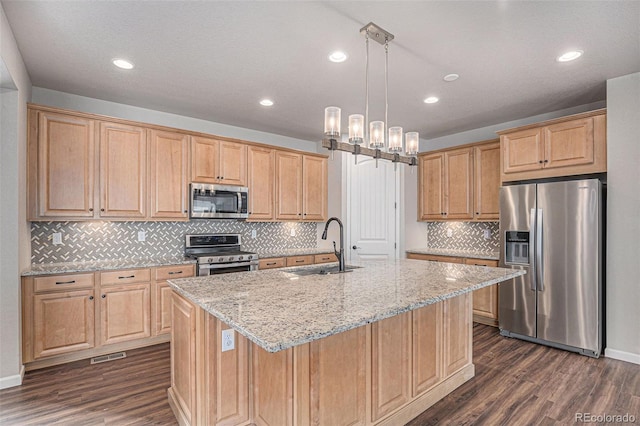 kitchen featuring a sink, light stone countertops, stainless steel appliances, and dark wood-style floors