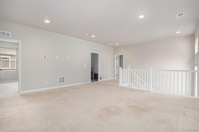 empty room featuring visible vents and light carpet