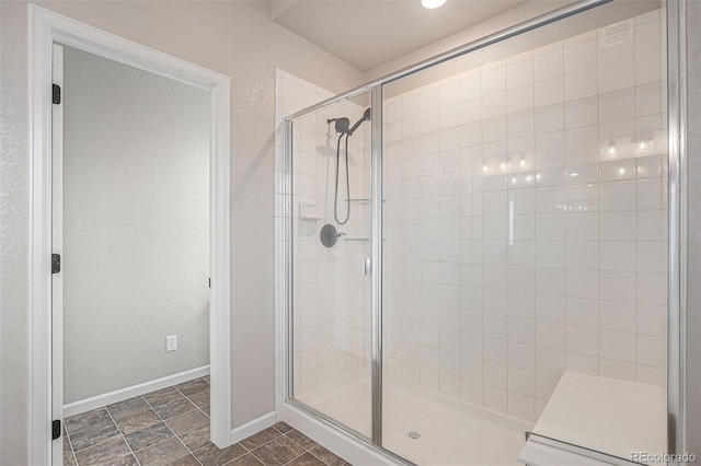 bathroom featuring baseboards and a shower stall