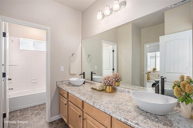 full bath with double vanity, a sink, and a healthy amount of sunlight