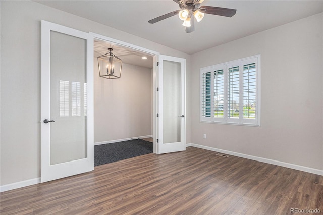 unfurnished bedroom featuring visible vents, baseboards, dark wood-style floors, french doors, and ceiling fan with notable chandelier