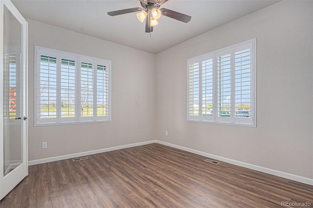 empty room featuring baseboards, visible vents, and a wealth of natural light