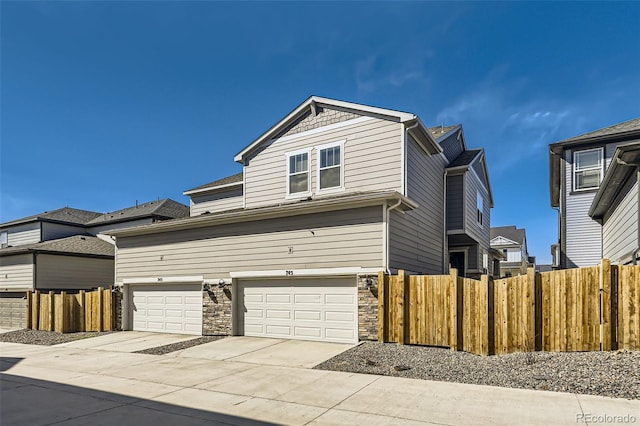 745 N Tempe St, Aurora, CO 80018 - view of front of property with concrete driveway, fence, and stone siding