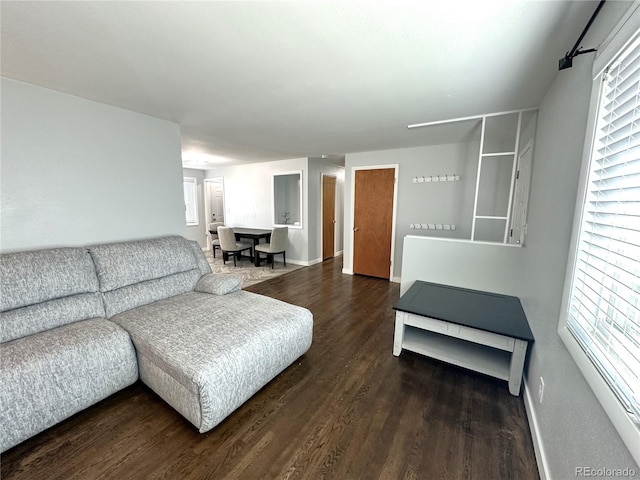 living area with baseboards and wood finished floors