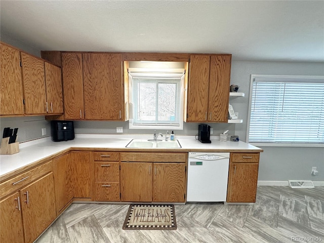 kitchen featuring open shelves, light countertops, visible vents, a sink, and dishwasher