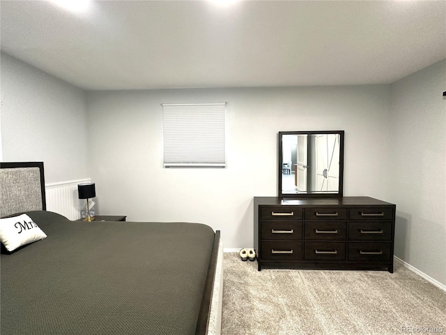 bedroom featuring light carpet and baseboards