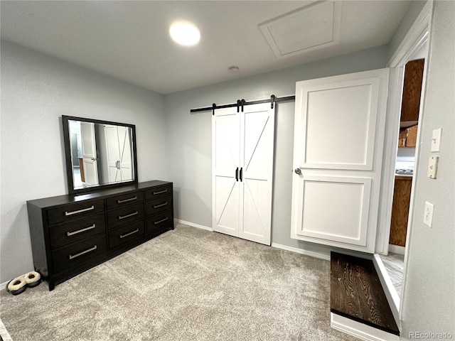 carpeted bedroom with baseboards and a barn door