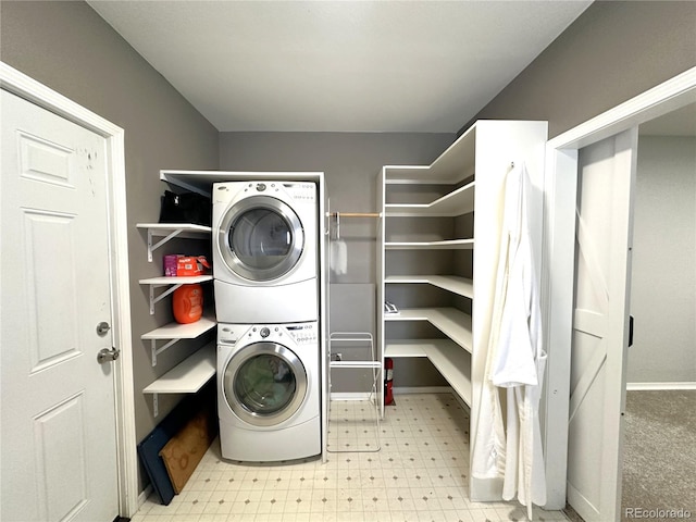 laundry room featuring stacked washer / dryer, laundry area, and tile patterned floors