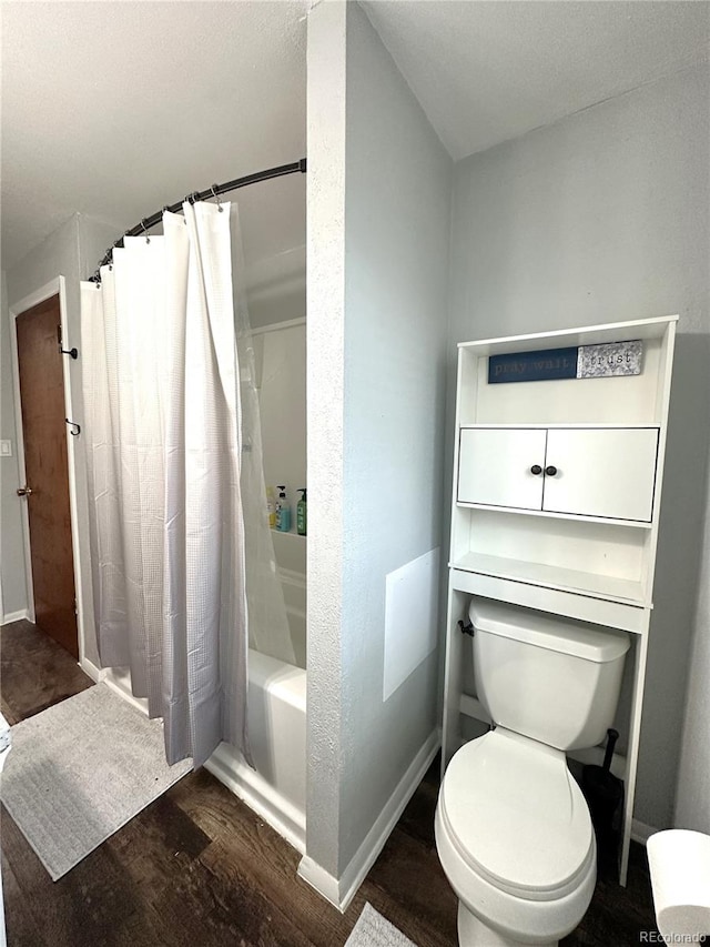 full bath with shower / bath combo with shower curtain, wood finished floors, toilet, and baseboards