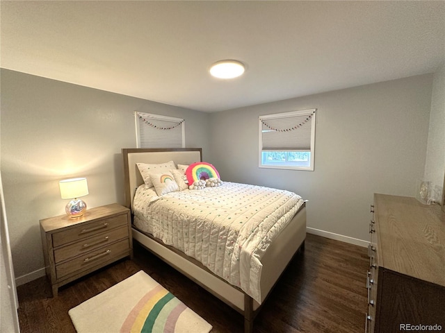 bedroom featuring baseboards and dark wood-type flooring