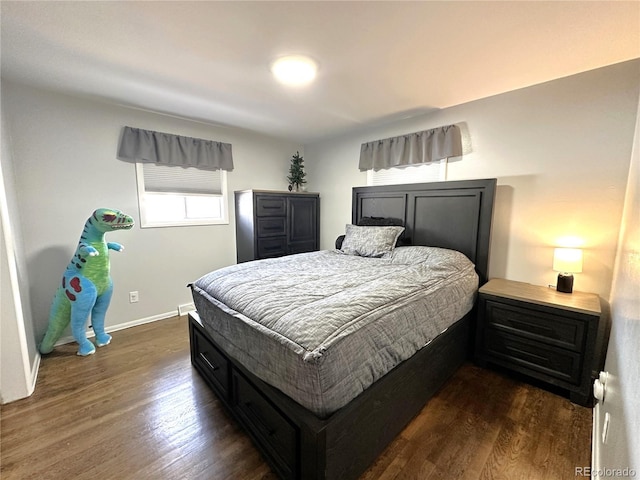 bedroom with baseboards and dark wood-type flooring