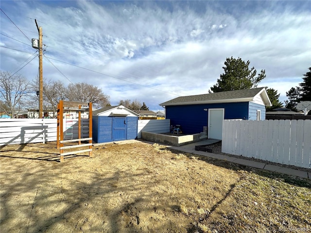 view of yard with an outdoor structure, a storage shed, and fence