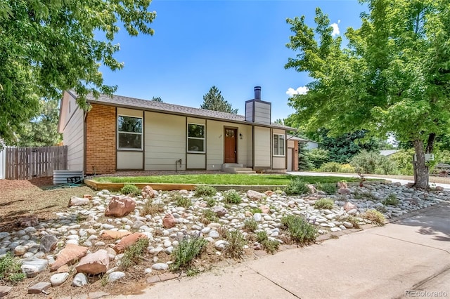 4064 S Olathe Ct, Aurora, CO 80013 - ranch-style home featuring a chimney, brick siding, and an attached garage